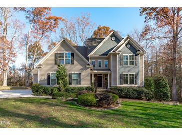 Two-story house with gray and beige siding, shutters, and landscaping at 4616 Transept Ct, Holly Springs, NC 27540