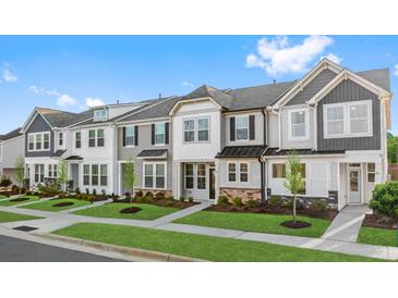 Row of charming townhouses with gray siding, stone accents, and manicured lawns at Tbd Channel Drop Dr # 123, Clayton, NC 27520