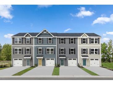 Four-unit townhome building with attached garages and neutral-toned siding at 323 Apricot Sun Way, Zebulon, NC 27597