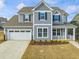 Gray two-story house with white trim, two-car garage, and landscaped front yard at 124 Crested Coral Dr, Holly Springs, NC 27540
