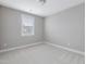 Bright bedroom featuring a window with blinds and neutral carpeting at 124 Crested Coral Dr, Holly Springs, NC 27540