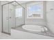 Bathroom with large soaking tub, glass shower, and granite vanity at 124 Crested Coral Dr, Holly Springs, NC 27540