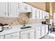 Kitchen boasts white cabinets, quartz countertops, and decorative tile backsplash at 40002 Worth, Chapel Hill, NC 27517
