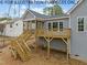 Home's rear elevation showcasing a screened porch and deck with stairs at 610 Sherron Rd, Durham, NC 27703