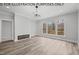 Gathering room with fireplace, hardwood floors, and large windows overlooking wooded area at 622 Sherron Rd, Durham, NC 27703
