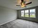 Spacious bedroom with gray carpeting, ceiling fan, and large windows at 40 Longbow Dr, Middlesex, NC 27557