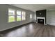 Living room with dark accent wall, fireplace, built-in shelving, and hardwood floors at 40 Longbow Dr, Middlesex, NC 27557