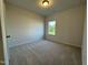 Well-lit bedroom with carpet and a window offering natural light at 116 Commons Cir # 229, Clayton, NC 27520