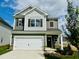 Two-story house with gray and white exterior, two-car garage, and landscaping at 116 Commons Cir # 229, Clayton, NC 27520
