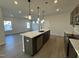 Open concept kitchen with island, stainless steel appliances, and hardwood floors at 116 Commons Cir # 229, Clayton, NC 27520