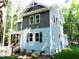 Two-story house with gray siding, showing side elevation and windows at 7647 Cummings Dr, Mebane, NC 27302