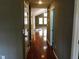 Bright hallway with hardwood floors and doors to other rooms at 7647 Cummings Dr, Mebane, NC 27302