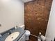 Small bathroom with brick accent wall and toilet at 124 Don Ron Rd, Erwin, NC 28339