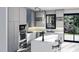Modern gray kitchen with white island and sliding glass door at 825 Antoine Dr # 7, Durham, NC 27713