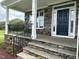 Stone and white porch with black railing and a dark-colored front door at 106 Ausban Rdg Ln # 002, Four Oaks, NC 27524
