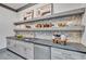 Well-designed kitchen pantry with gray shaker cabinets, quartz countertops, and open shelving at 1312 Hunting Ridge Rd, Raleigh, NC 27615
