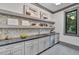 Modern kitchen pantry with gray shaker cabinets, quartz countertops, and open shelving at 1312 Hunting Ridge Rd, Raleigh, NC 27615