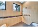 Spa-like shower with multiple shower heads and wood-look tile at 1312 Hunting Ridge Rd, Raleigh, NC 27615
