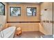Spa-like bathroom with freestanding soaking tub, walk-in shower, and large windows at 1312 Hunting Ridge Rd, Raleigh, NC 27615