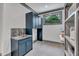 Functional laundry room with ample storage, granite countertop, and blue cabinets at 1312 Hunting Ridge Rd, Raleigh, NC 27615