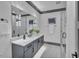 Modern bathroom with gray vanity, marble countertops, and a large mirror at 1312 Hunting Ridge Rd, Raleigh, NC 27615