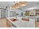 Modern kitchen island with waterfall quartz countertop, built-in cutting board, and wine fridge at 1312 Hunting Ridge Rd, Raleigh, NC 27615
