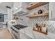 Modern kitchen features a gas range, white cabinets, and marble countertops at 1312 Hunting Ridge Rd, Raleigh, NC 27615