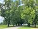 Community entrance with tree-lined road and green landscape at 73 Sage Ln # 008, Four Oaks, NC 27524