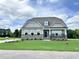 Two story home with stone accents and a landscaped lawn at 103 Sage Ln # 009, Four Oaks, NC 27524