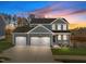 Two-story home with gray siding, two-car garage, and landscaped front yard at 305 Sutherland Dr, Franklinton, NC 27525