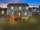 Two-story house with deck and stairs, surrounded by a grassy yard at dusk at 305 Sutherland Dr, Franklinton, NC 27525