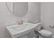 Clean bathroom featuring a pedestal sink, toilet, and a large vanity mirror at 345 Sutherland Dr, Franklinton, NC 27525