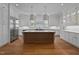 Modern kitchen with white cabinets, a large island with a waterfall edge, and stainless steel appliances at 2635 Marchmont St, Raleigh, NC 27608