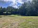 Backyard view featuring green grass and trees, with a partial construction view at 43 Laurel Knoll Dr, Pittsboro, NC 27312