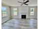 Spacious living room with fireplace, hardwood floors, and large windows at 12620 Boarder Creek Ln, Zebulon, NC 27597