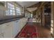 Modern kitchen with white cabinets, brick floor and view into dining area at 6720 Mebane Oaks Rd, Mebane, NC 27302