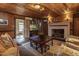 Rustic living room featuring exposed beams, fireplace, and comfortable seating at 6720 Mebane Oaks Rd, Mebane, NC 27302
