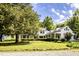 White farmhouse with a gravel driveway at 6720 Mebane Oaks Rd, Mebane, NC 27302