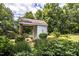 White shed with brick base, surrounded by lush greenery at 6720 Mebane Oaks Rd, Mebane, NC 27302