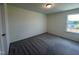 Bright bedroom with window, gray carpet, and a door at 352 Chestnut Oak Ln, Lillington, NC 27546