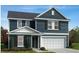 Two-story home with blue siding and white garage door at 352 Chestnut Oak Ln, Lillington, NC 27546