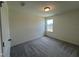 Bright bedroom with grey carpet and a window overlooking backyard at 352 Chestnut Oak Ln, Lillington, NC 27546