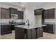 Modern kitchen with island, stainless steel appliances, and dark cabinetry at 127 Hillwood Dr, Sanford, NC 27332