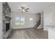 Living room with hardwood floors, a stone fireplace, and a ceiling fan at 53 Hillwood Dr, Sanford, NC 27332