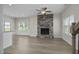 Living room with hardwood floors, a stone fireplace, and a ceiling fan at 53 Hillwood Dr, Sanford, NC 27332