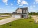 Two-story house with gray siding, a three-car garage, and a well-manicured lawn at 188 Hillwood Dr, Sanford, NC 27332