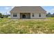 Tan house with covered patio and grassy backyard at 58 Hillwood Dr, Sanford, NC 27332