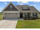 House with two-car garage, stone accents, and a landscaped yard at 58 Hillwood Dr, Sanford, NC 27332
