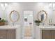 Elegant primary bathroom with dual vanities and a doorway to walk-in closet at 3401 Makers Cir, Raleigh, NC 27612