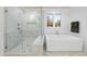 Modern bathroom featuring a glass shower, soaking tub, and marble tile at 3401 Makers Cir, Raleigh, NC 27612